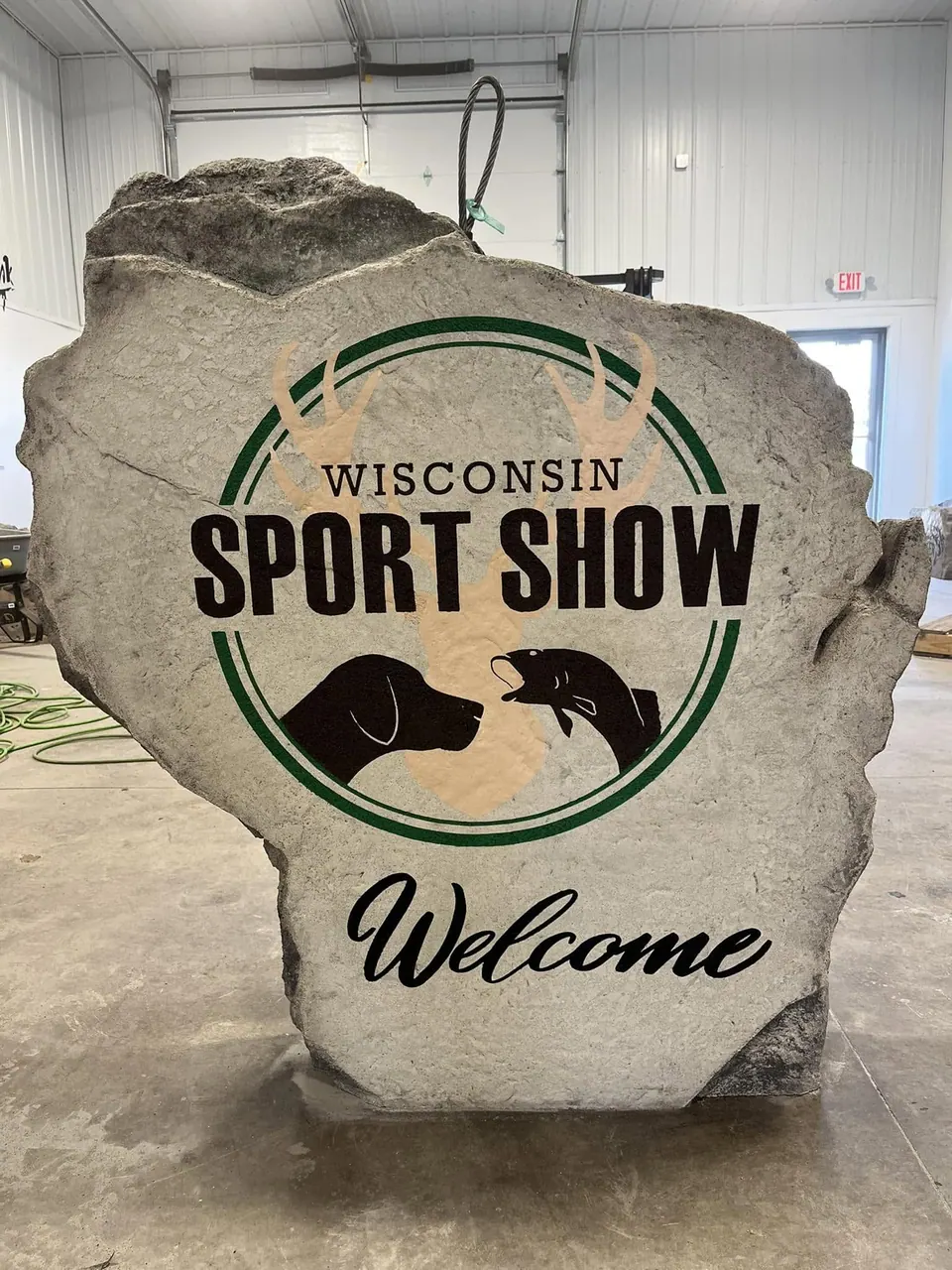 Wisconsin-shaped event welcome boulder with a full-color sport show logo