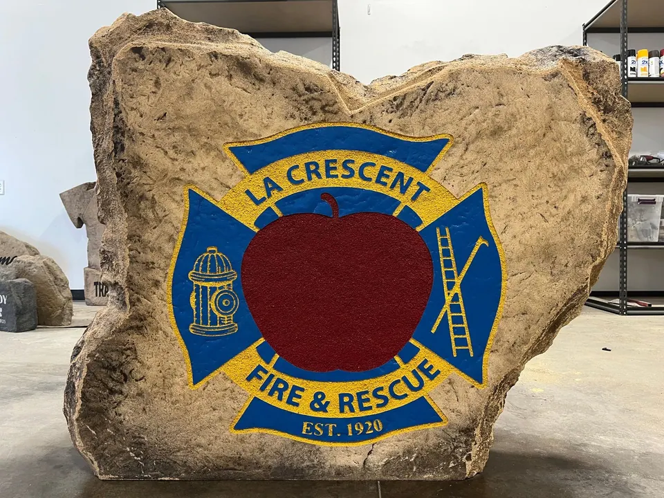 Large boulder with a full-color fire and rescue department emblem, finished in our shop