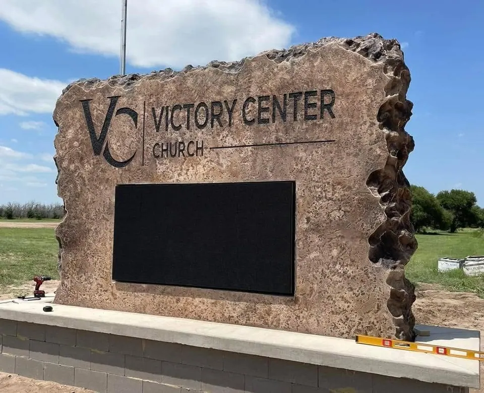 Church boulder sign with engraved lettering and a built-in LED message board on a concrete base