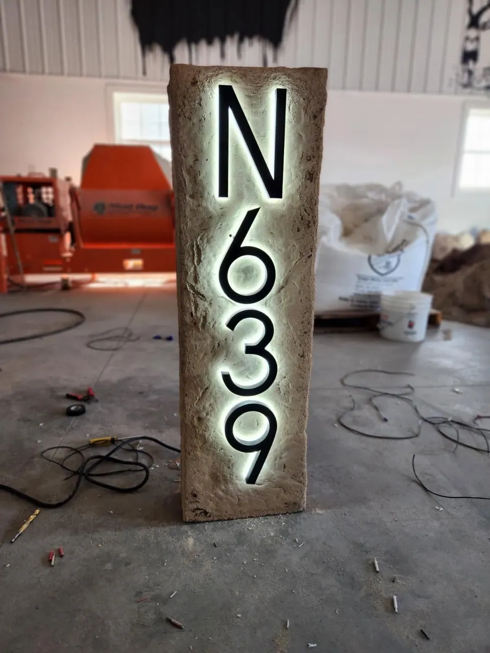 Tall address column boulder with backlit house numbers, shown in our shop