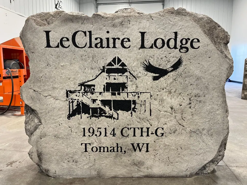 Engraved lodge sign boulder with a drawing of the lodge and an eagle