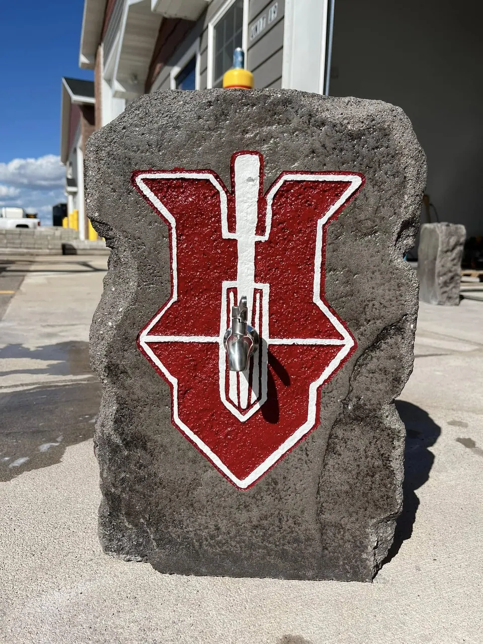 Upright boulder with a bold red and white emblem logo