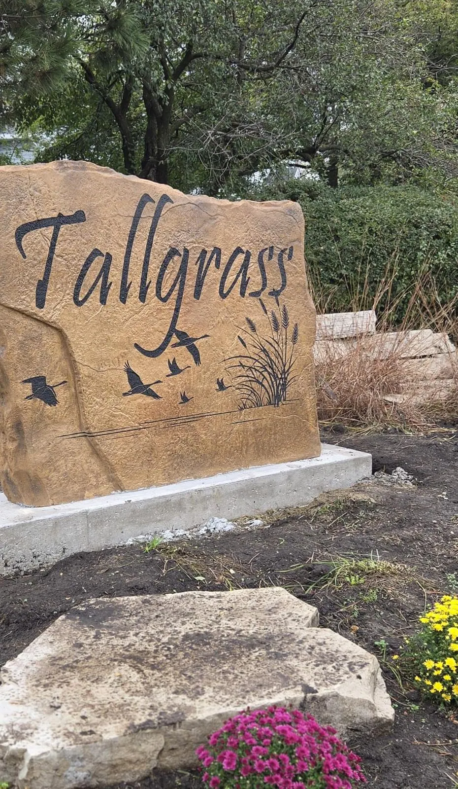 Close-up of the deep script lettering and geese engraved on the Tallgrass entrance monument