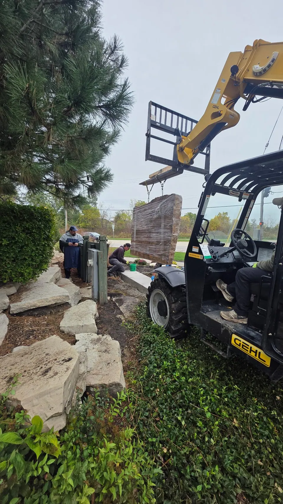 Telehandler lifting a boulder at the Tallgrass entrance