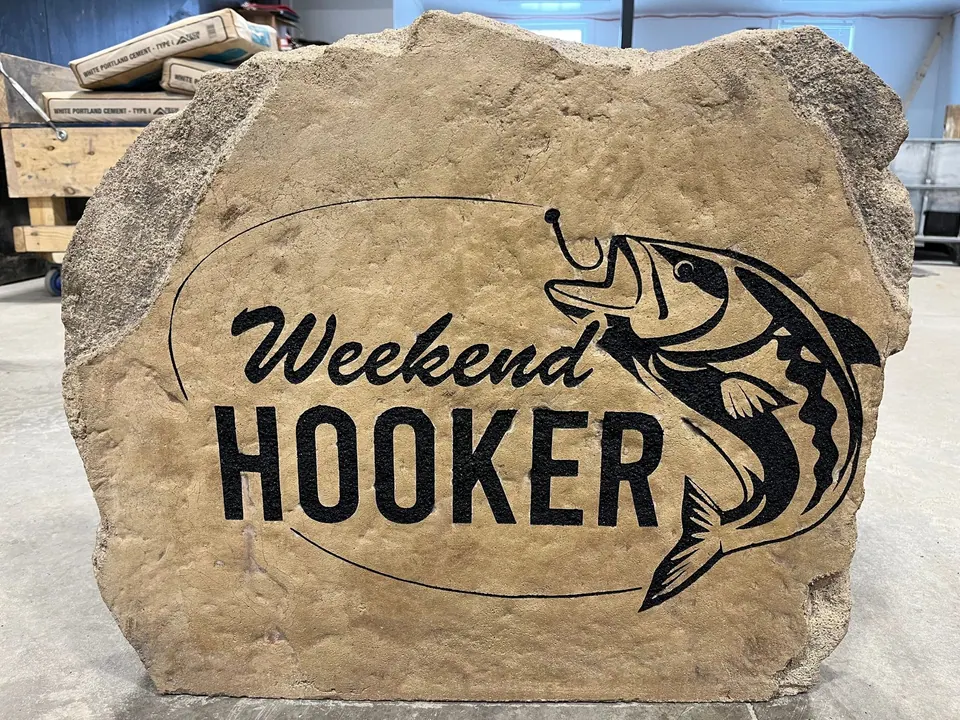 Cabin boulder with a fishing theme: a leaping fish and bold lettering